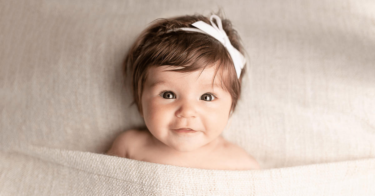 baby girl looking at camera smiling 