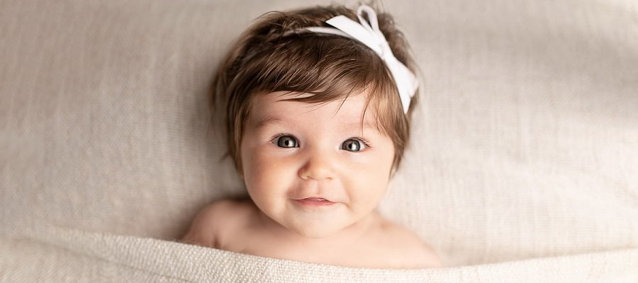 baby girl looking at camera smiling