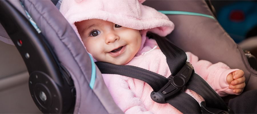Happy baby girl in a car seat