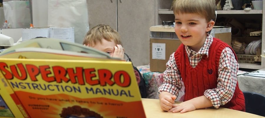 kids looking at superhero book